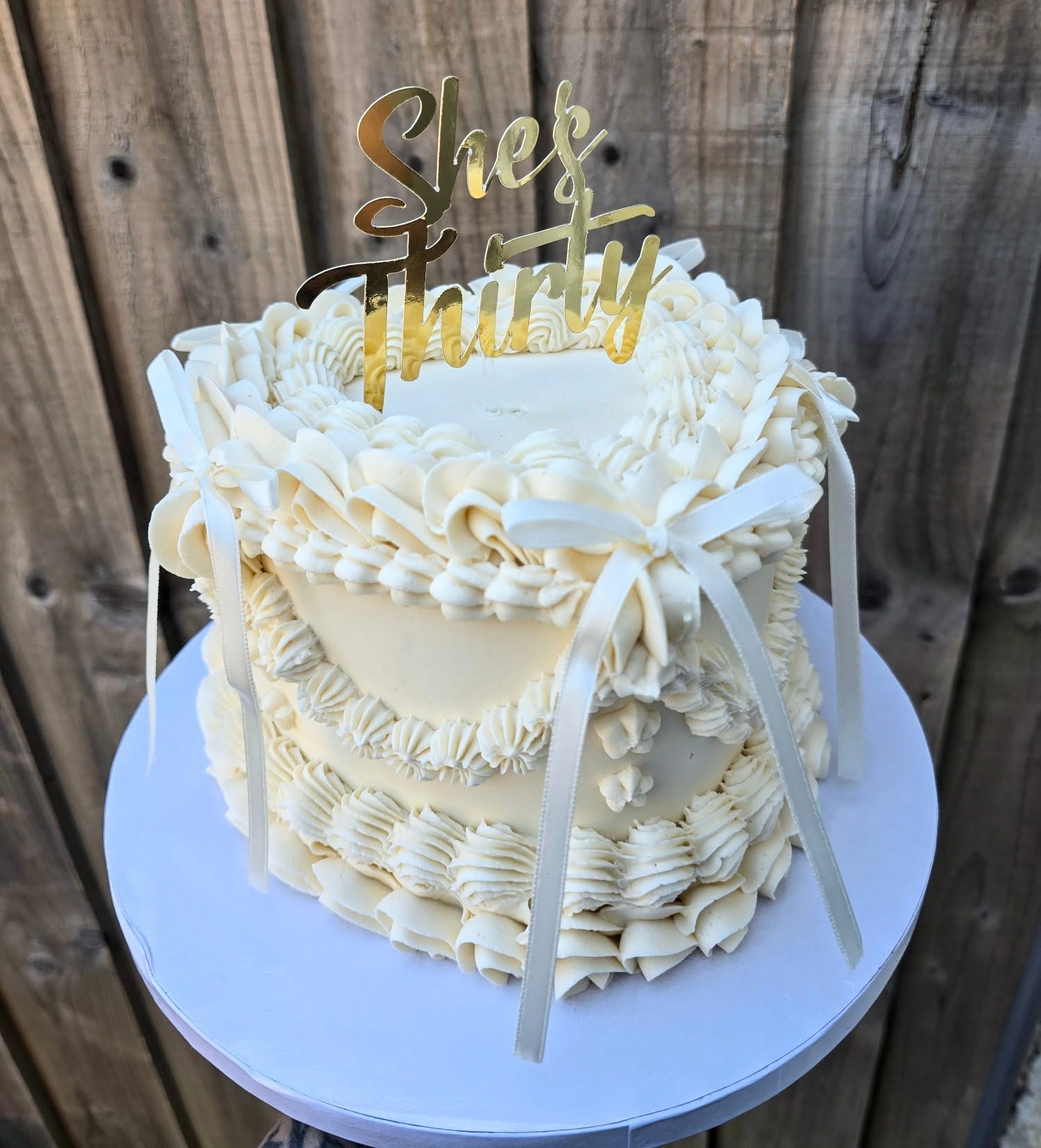 Classic white piping and golden details for a milestone birthday.